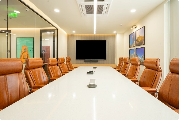 Walter P Moore modern conference room with a long white table, brown leather chairs, TV screen, and framed photos on walls.