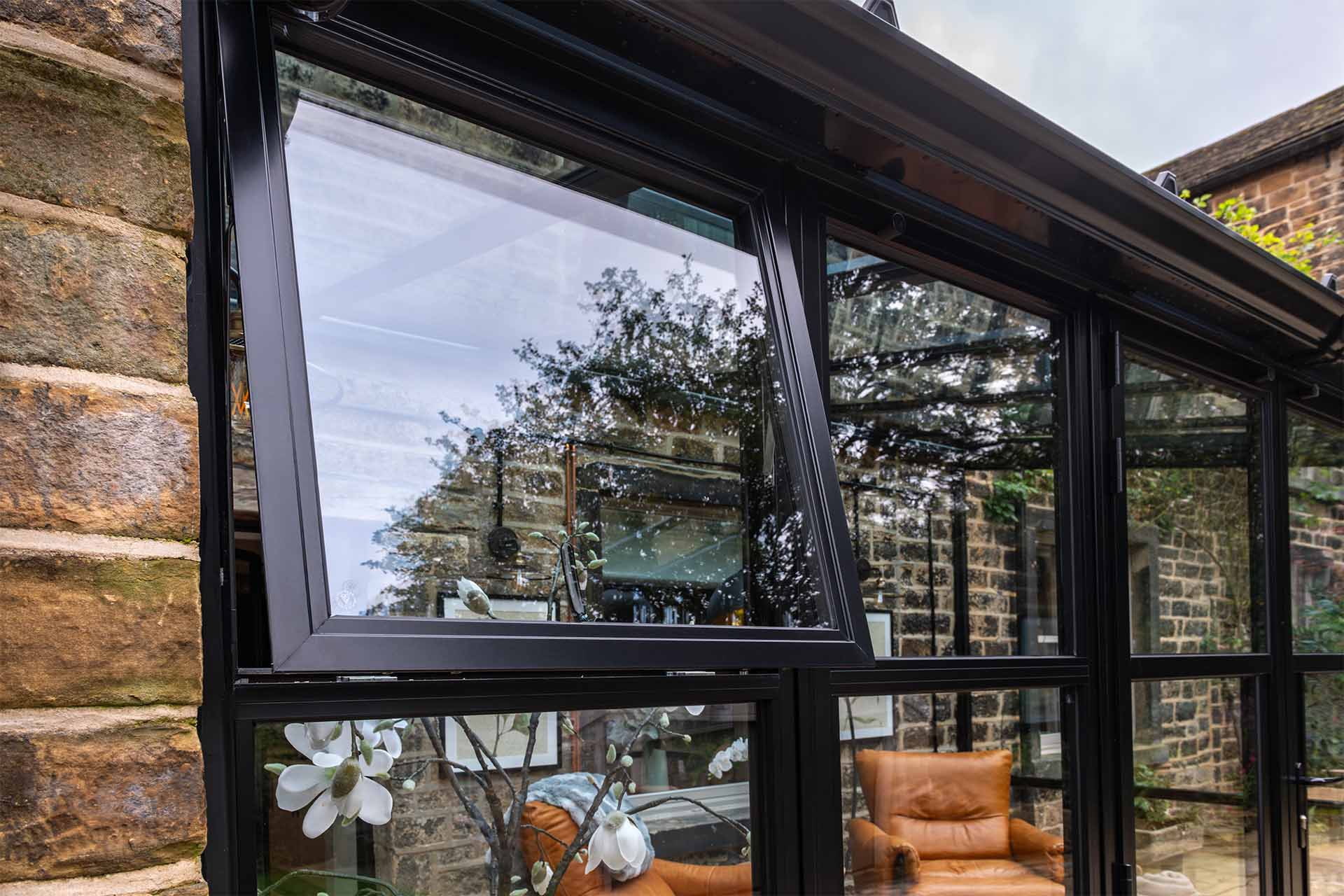 Black steel look aluminium windows in a traditional brick extension