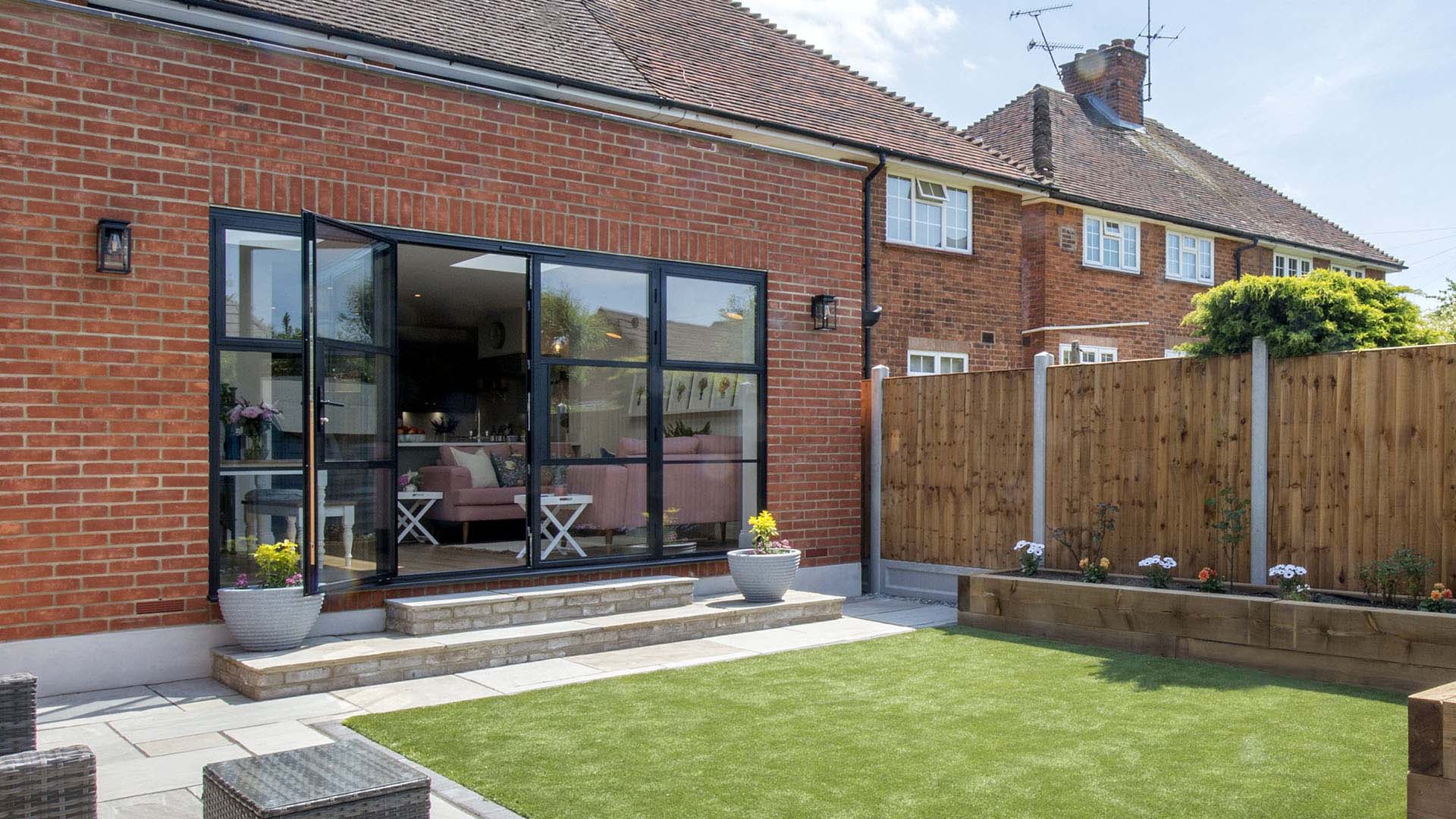 Garden showing aluminium  black steel look doors looking over a modern garden