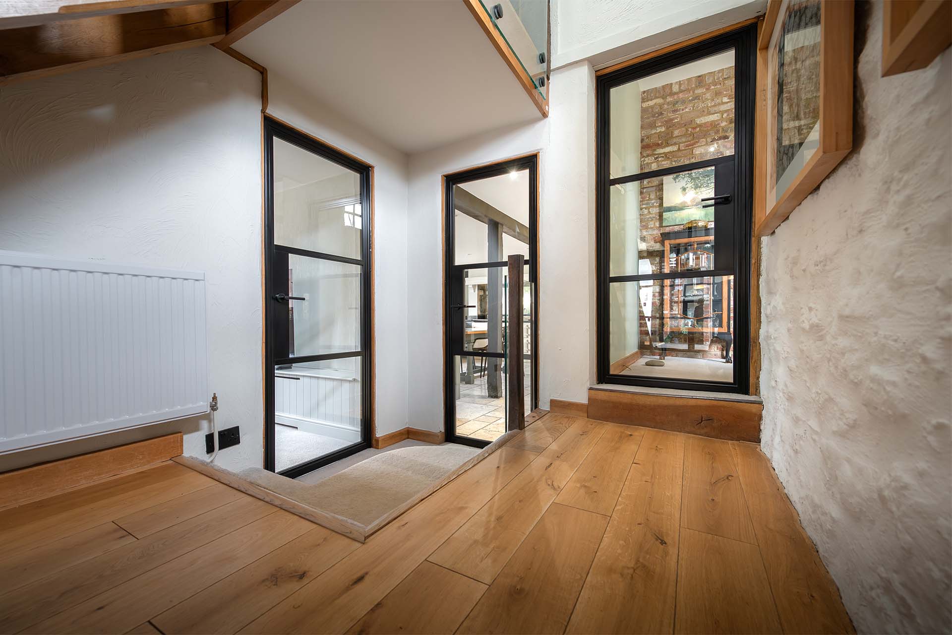 Three steel look doors leading into a barn conversion hallway