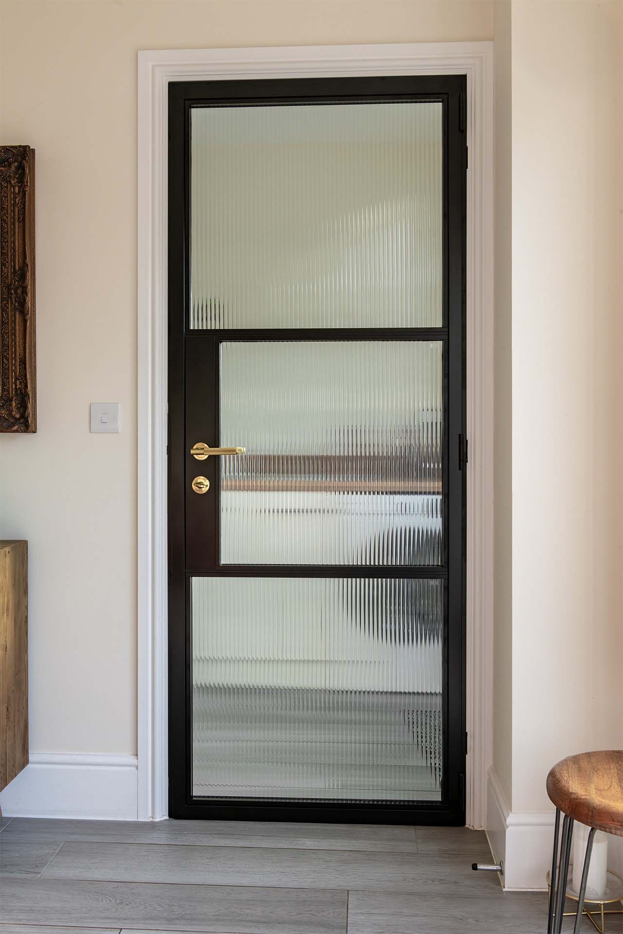Black aluminium internal door with reeded glass