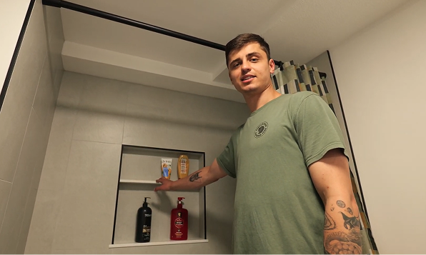 Stan points to the custom recessed niche in this new, fully renovated shower during a final walkthrough.