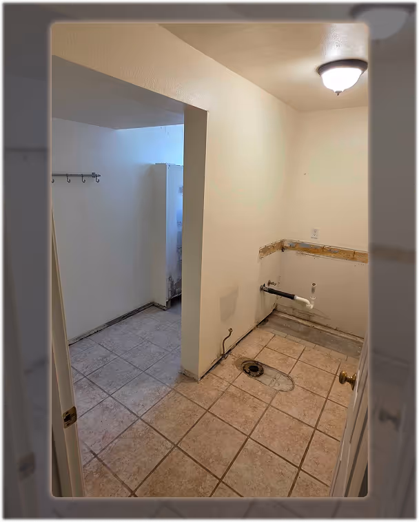 Before photo of an outdated bathroom with old tile flooring and removed vanity and toilet.