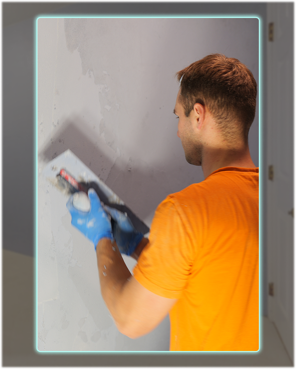 Installer applying microcement by hand with a trowel to create a smooth, textured finish.