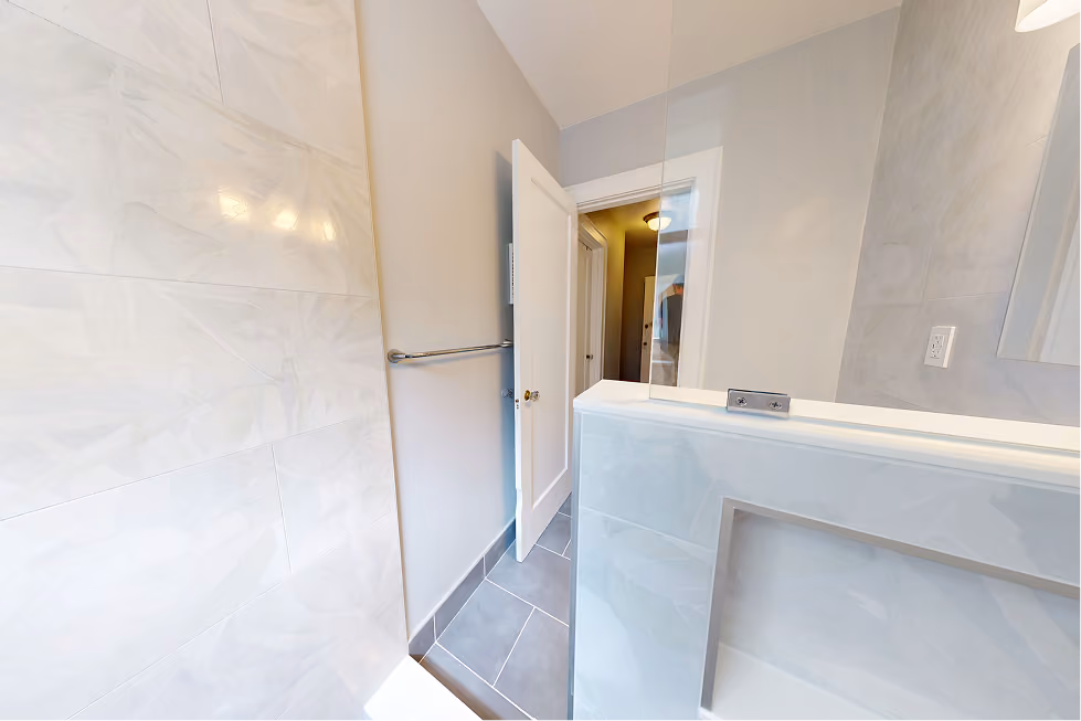 Frameless glass panel on a tiled pony wall in a remodeled Capitol Hill walk-in shower