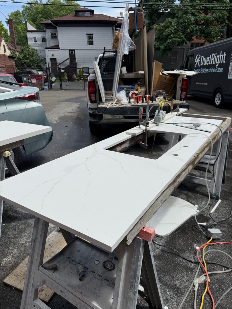 Quartz countertop slabs on sawhorses in the alley during template and fitting day