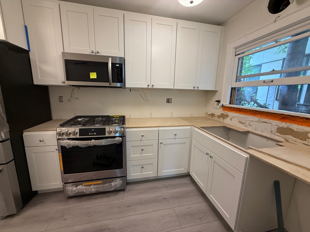 Wide view of the Capitol Hill condo kitchen during install week with cabinets and appliances in place
