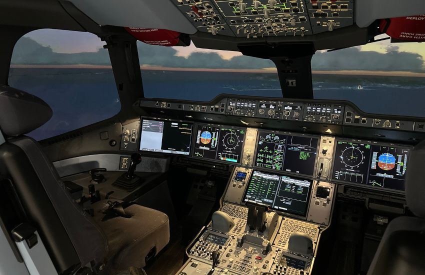 A highly detailed Airbus A350 flight simulator cockpit with multiple digital displays, control panels, and seats, situated in a training laboratory likely at Hong Kong Metropolitan University, showcasing advanced aviation technology and pilot training facilities.
