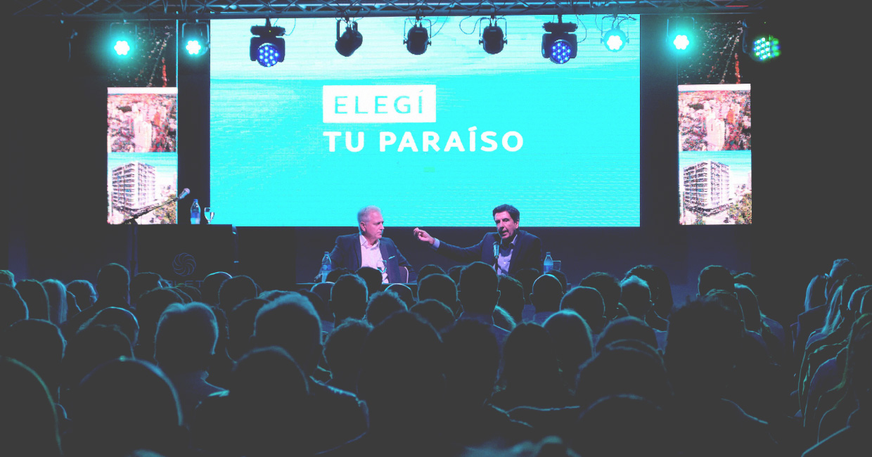 Panel de conferencia con pantalla gigante y público