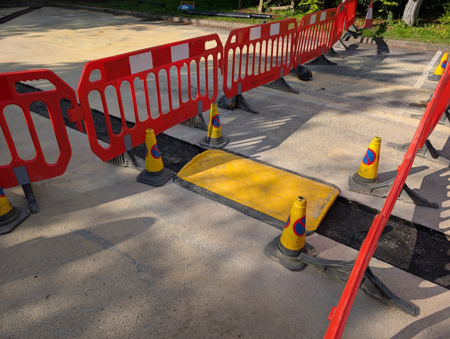 Open trench protected with a temporary plate, barriers and cones