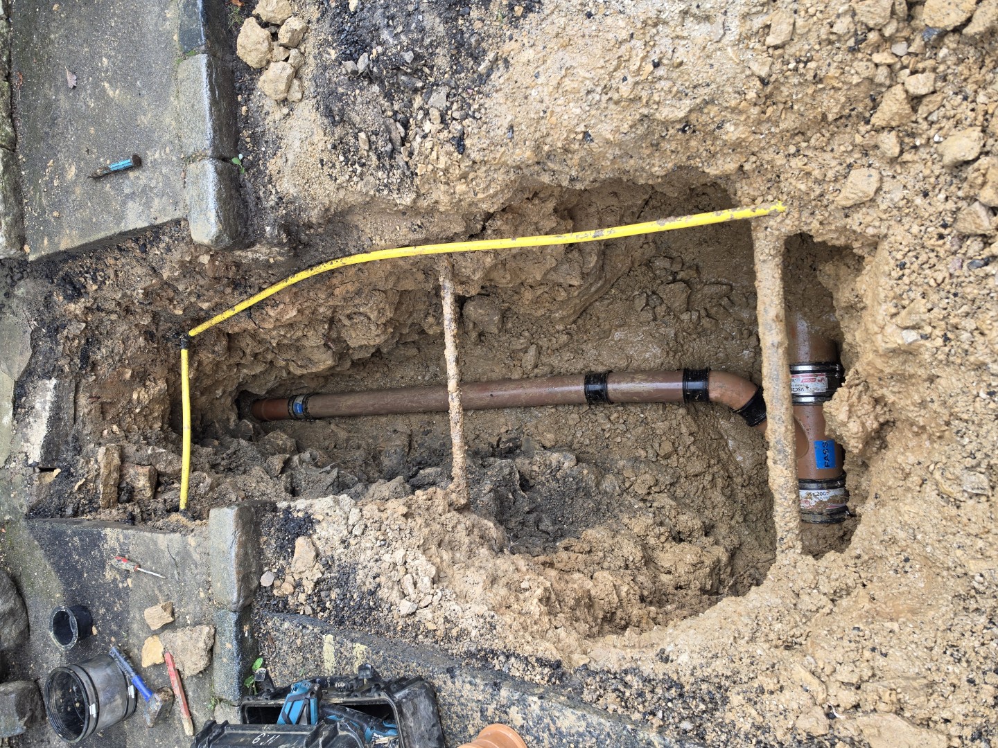 Excavation exposing buried pipework for a repair