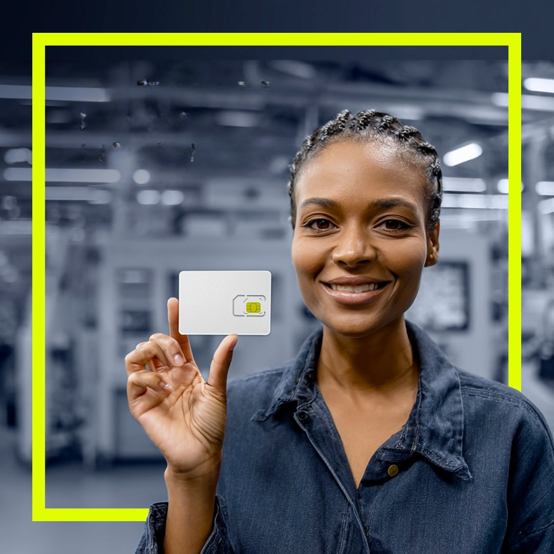 Lady in control room with SIM card in hand smiling