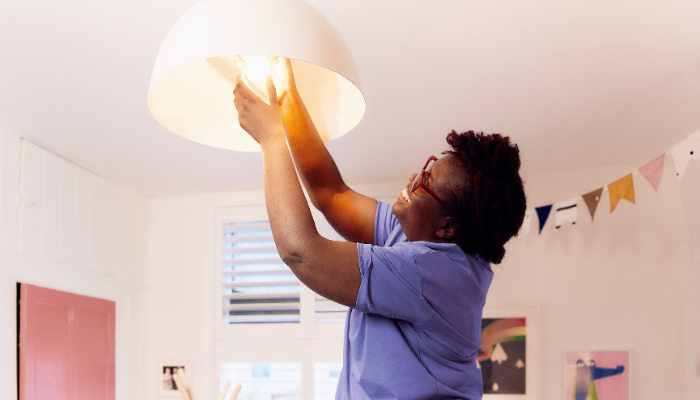 Female electrician changing bulb