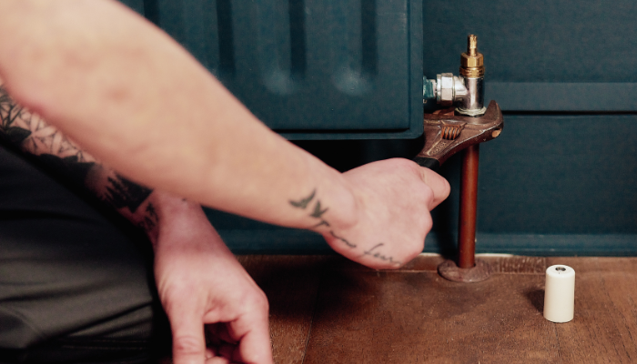 Female plumber working on a domestic radiator