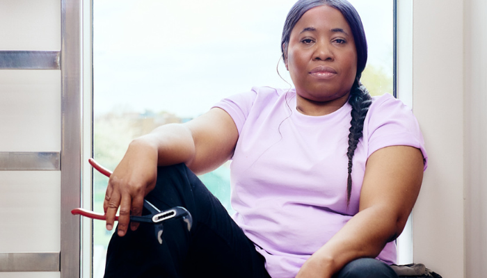 Female plumber sat next to window with her tools