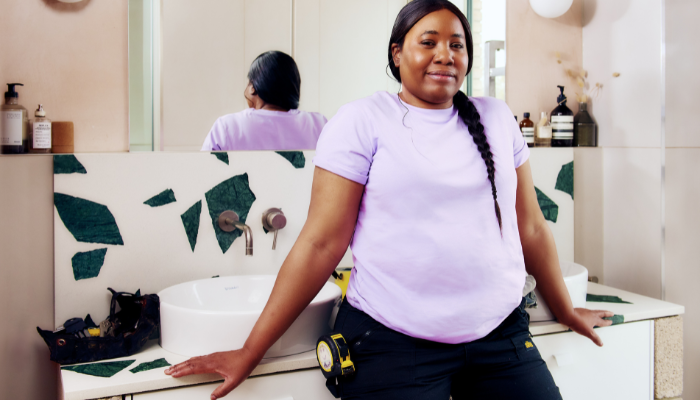 Female plumber standing next to bathroom sink