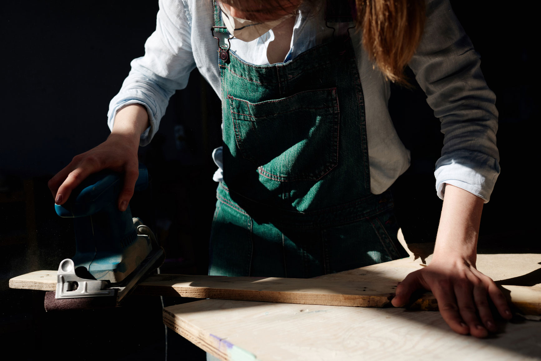 Female handywoman in Highgate, sanding wood with a power sander, TaskHer