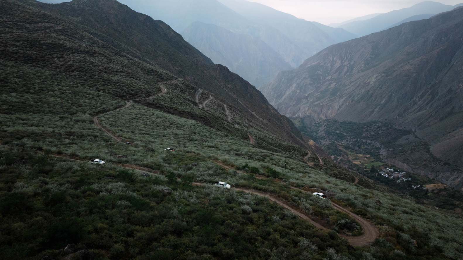 4WD vehicles travelling along a steep switchback trail in the Peruvian Andes