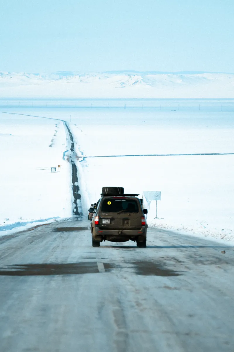 A Land Cruiser on an icy road across the snow-covered steppe, Mongolia