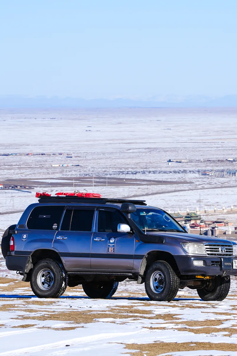 A Land Cruiser parked on the snowy plain near Kharkhorin, Mongolia