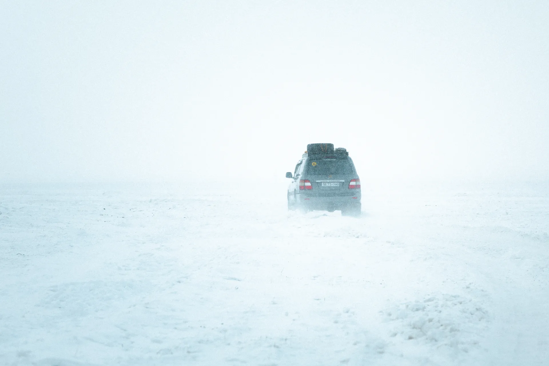 A Land Cruiser driving through a snowstorm on the frozen Mongolian steppe, Frozen Frontier expedition