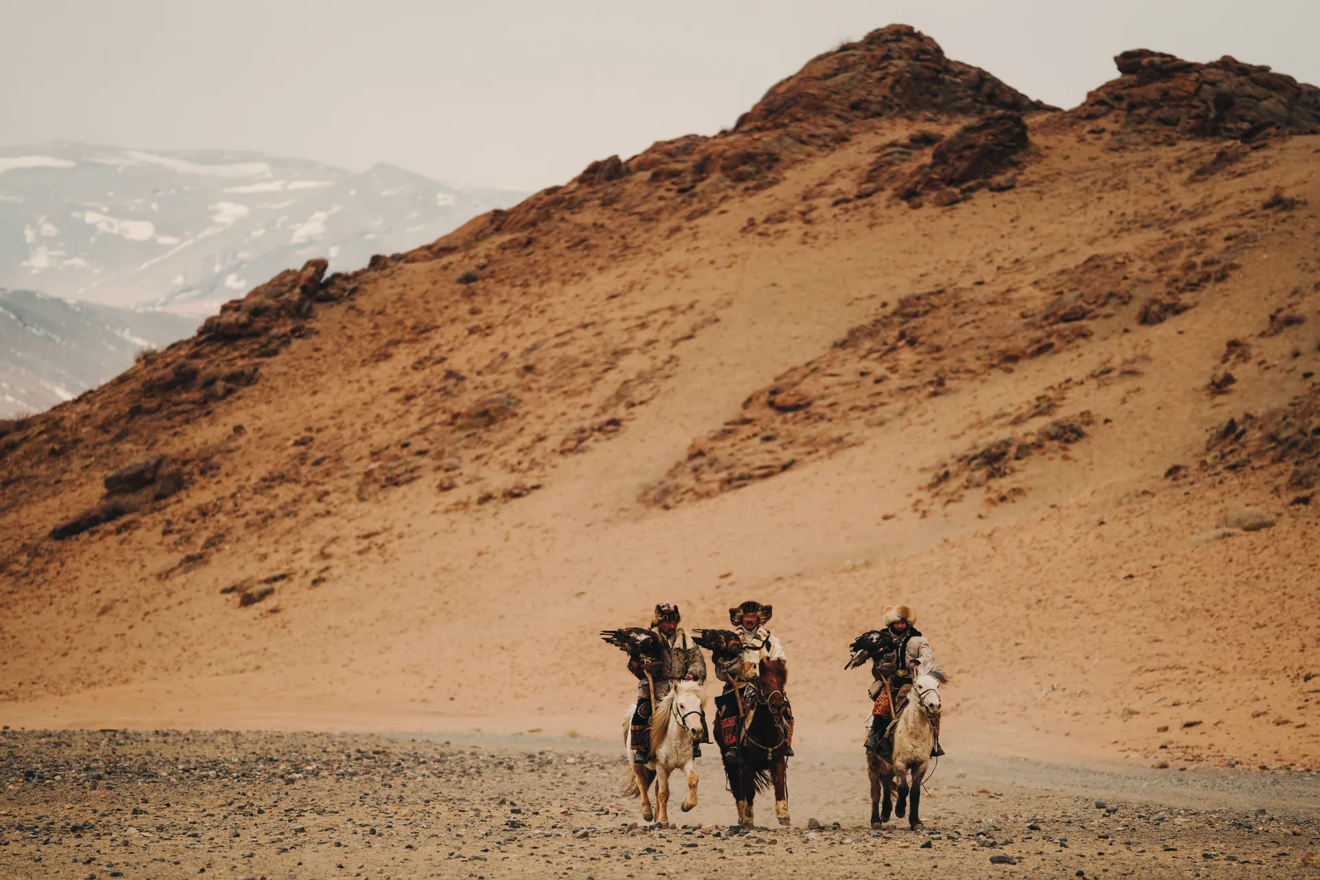 Kazakh eagle hunters on horseback in the foothills of the Altai, Mongolia