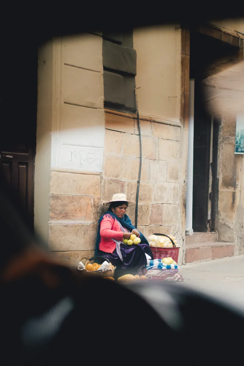 A street vendor seen through the window of a 4x4 in a Bolivian town