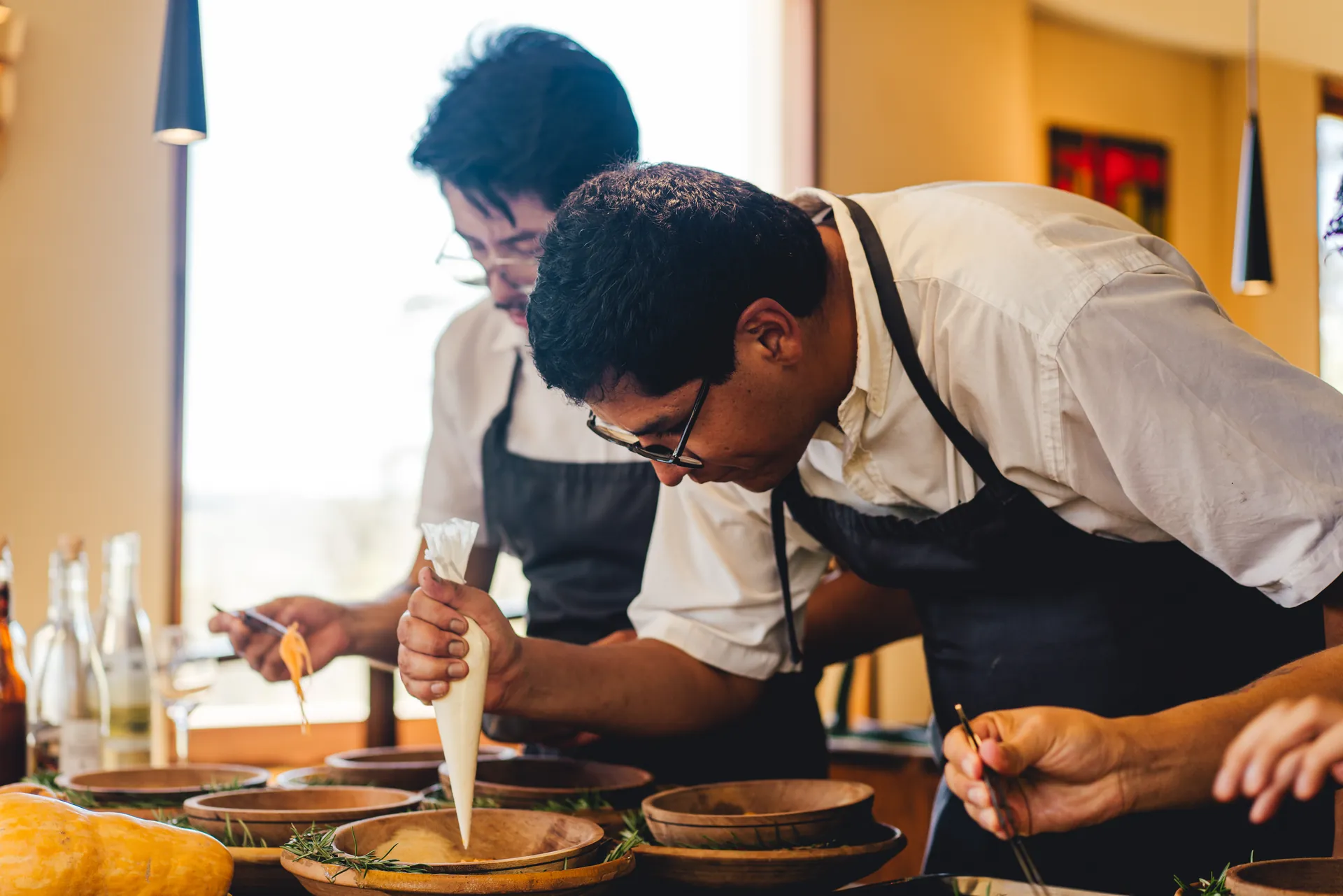 Chefs plating dishes in a restaurant kitchen, Bolivia