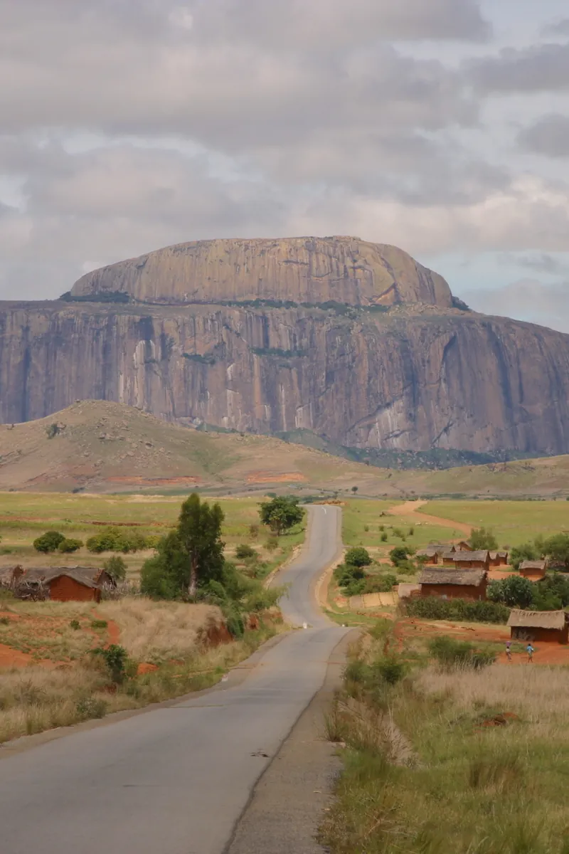 A road crossing the savannah below a sandstone massif in central Madagascar