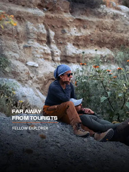 A fellow explorer resting below a rocky cliff on a Nomadic Road expedition: Far away from tourists