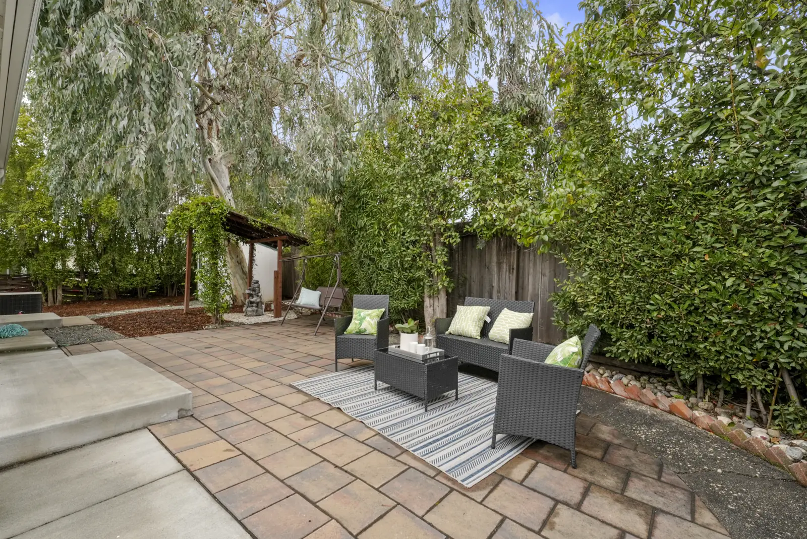 Backyard patio framed by mature trees