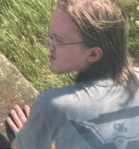 A person with long hair wearing glassesDescription automatically generated