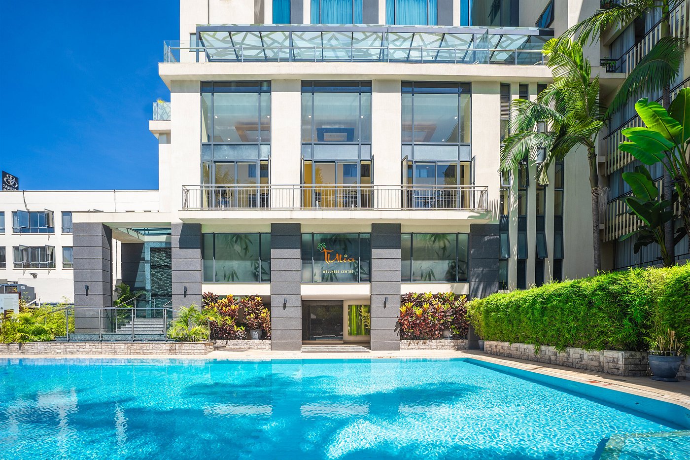 Sarova Panafric view - with large windows and a clear blue swimming pool in front, surrounded by greenery.