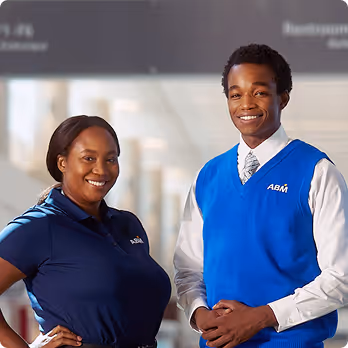 A woman and a man in ABM uniforms smiling and posing for a photo together