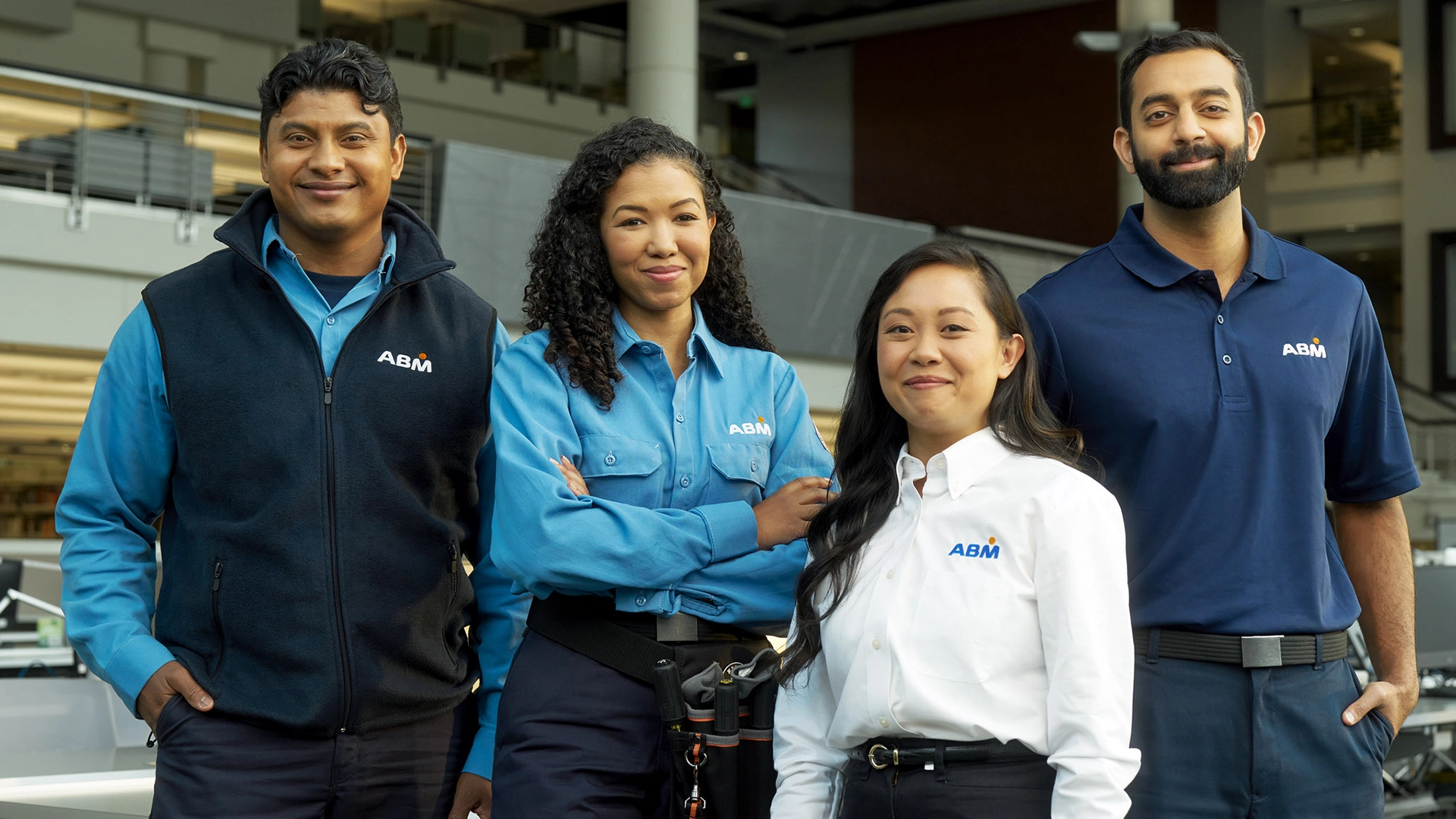 Four smiling people in ABM uniforms standing together outside