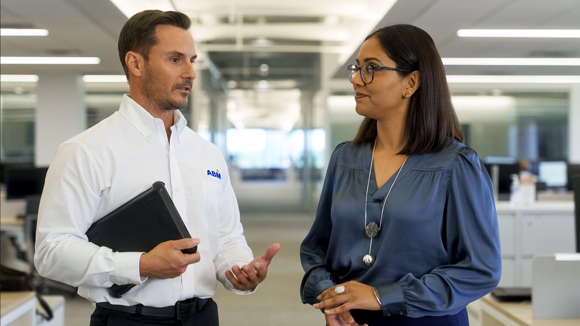 A man and a woman having a conversation in an office setting