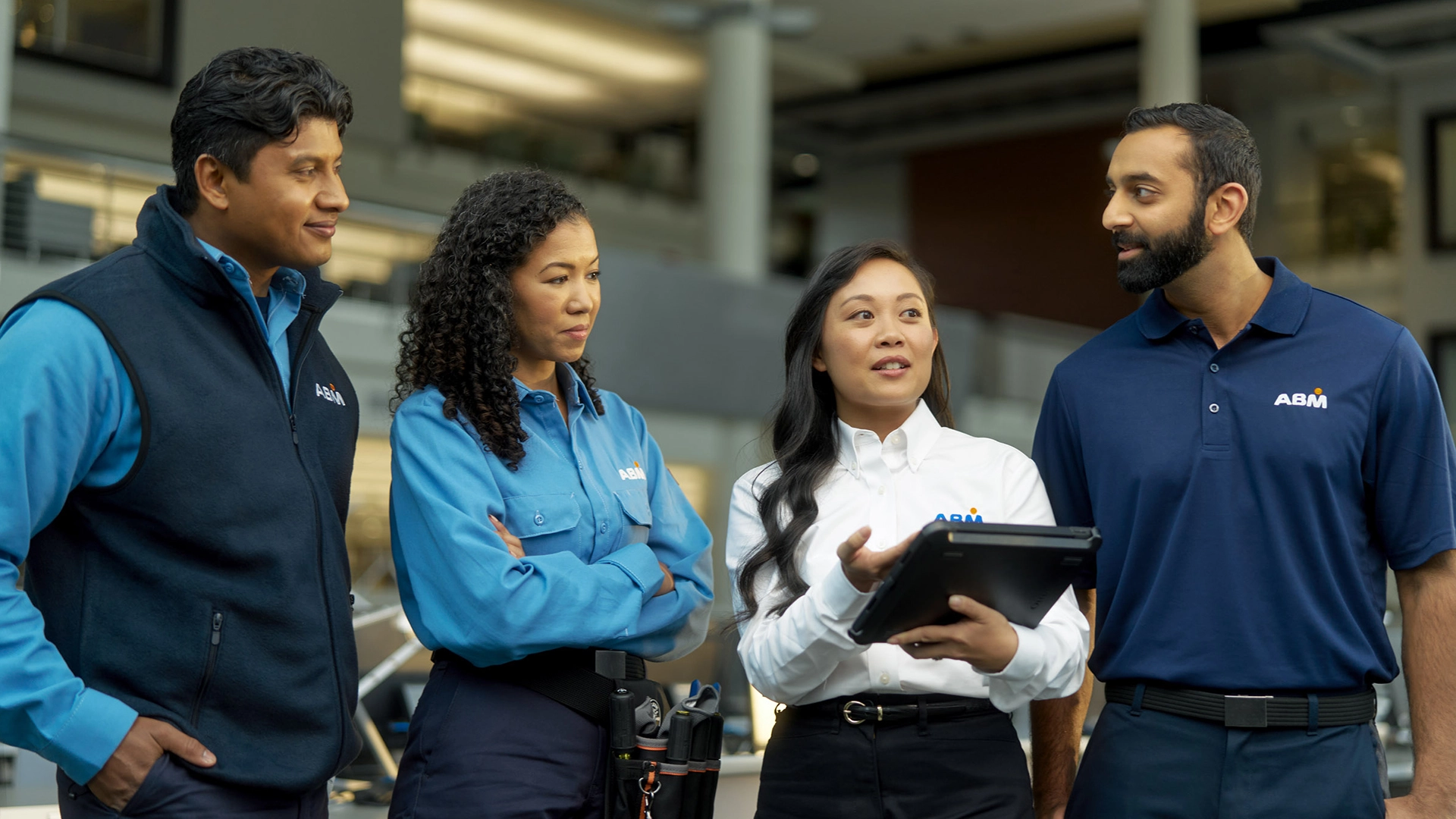 Four people in ABM uniforms standing outside, having a conversation