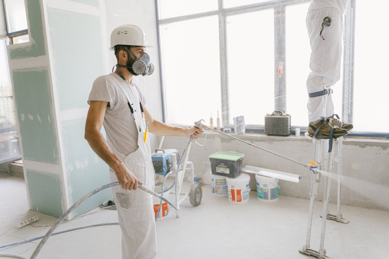 A man in white is painting a commercial building.