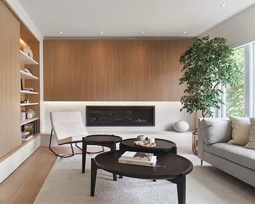 Design living room with a wood-slat wall, built-in fireplace, and custom bookshelf