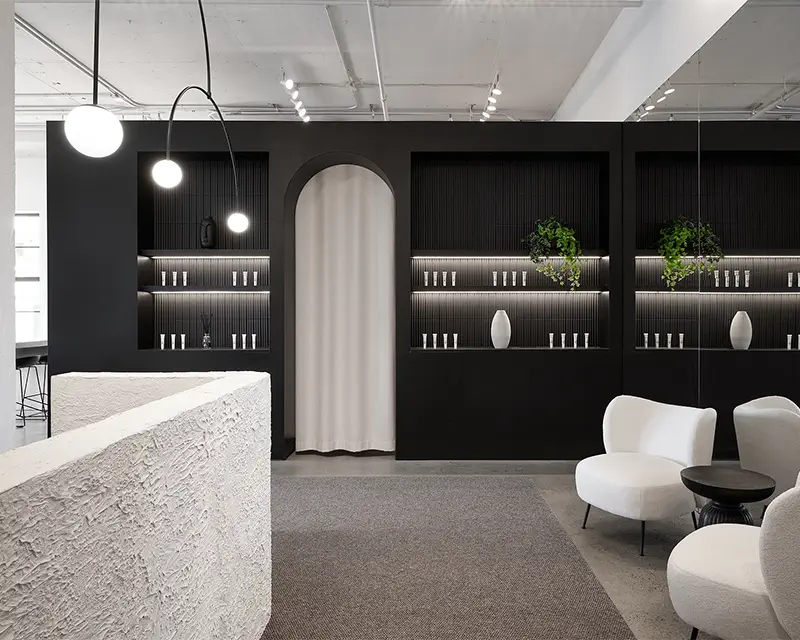 Reception area with a black fluted wall and a curved arch