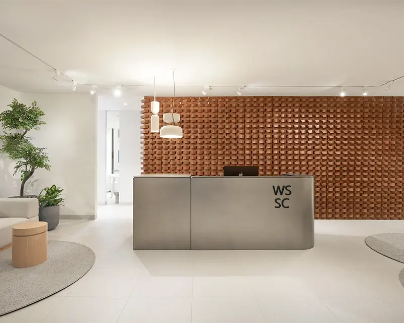Reception area with a woven brick wall and a steel counter