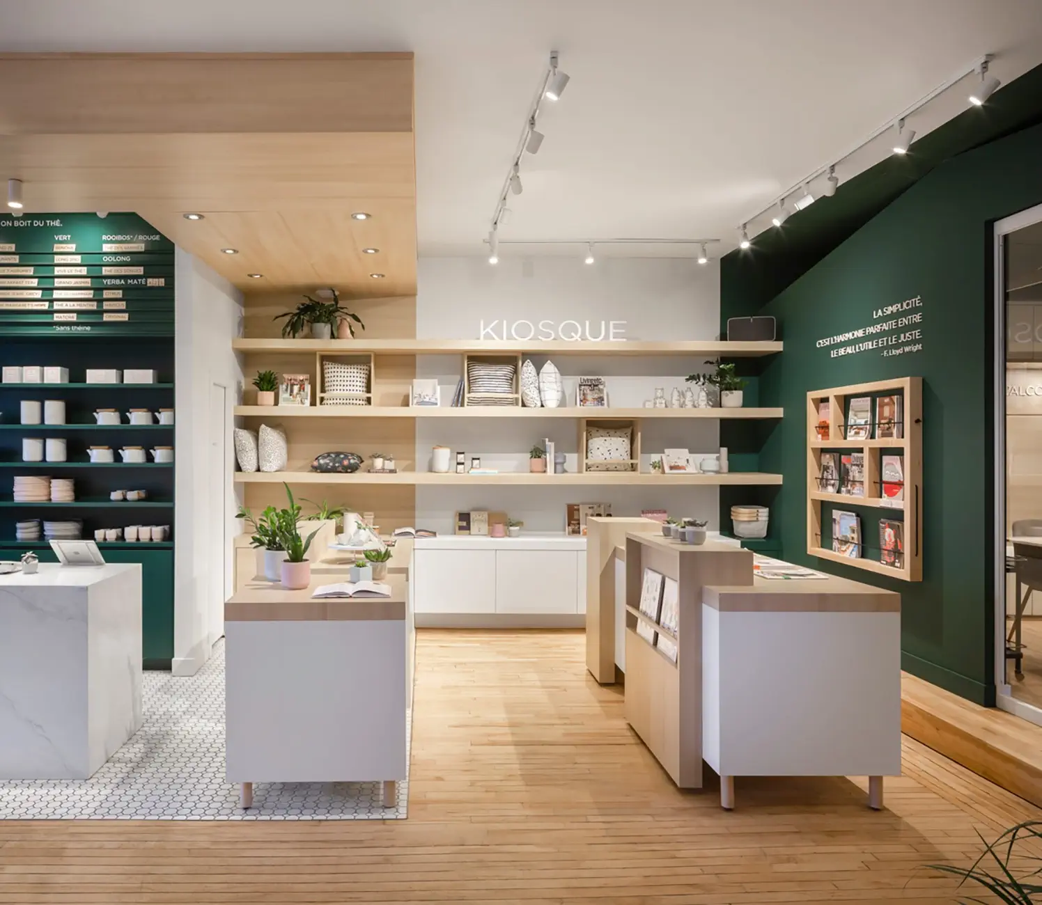 Kiosk-style shop with wooden shelves, display cases, and a forest-green wall