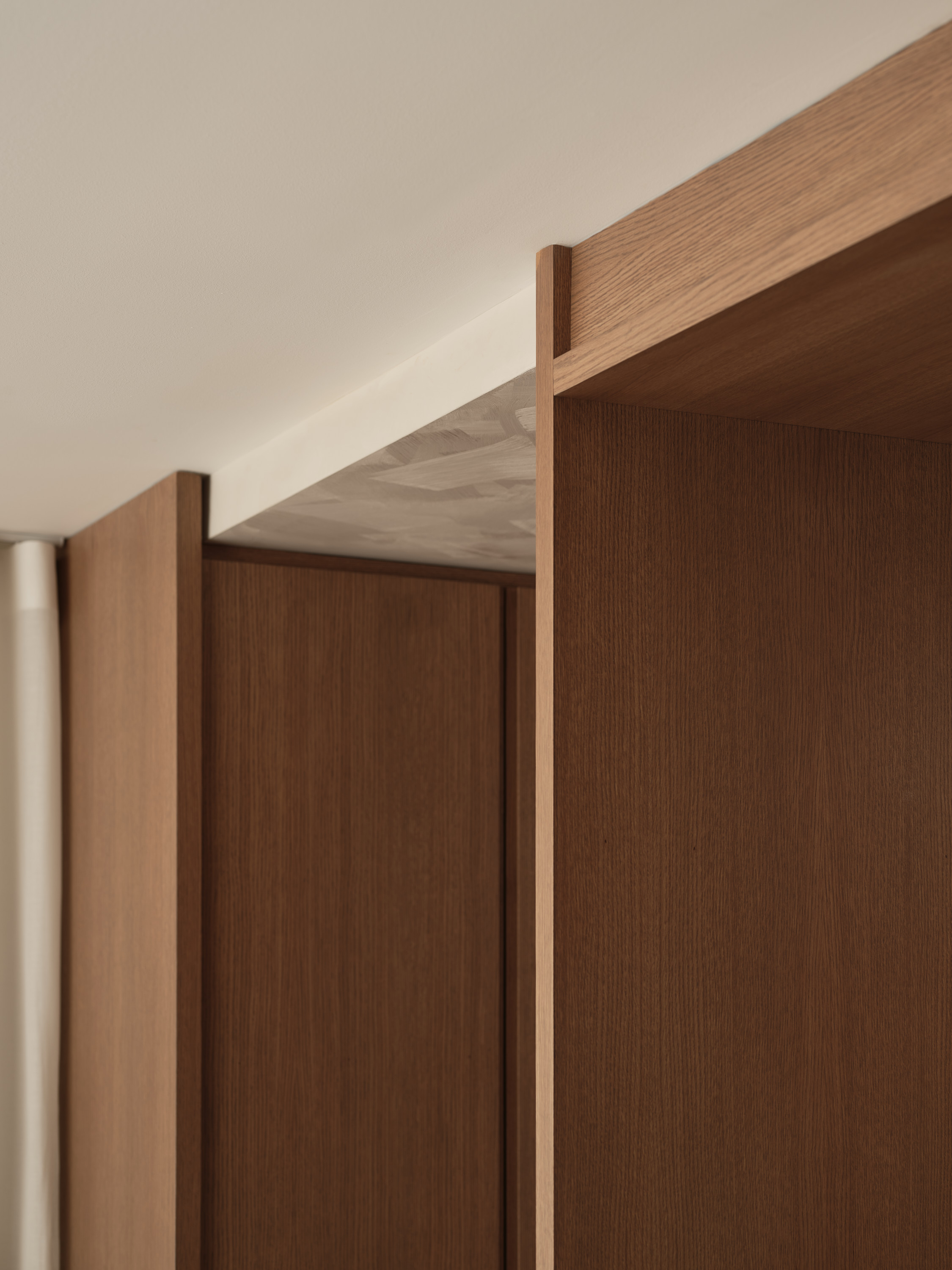 Architectural detail of a wooden ceiling box, where the panels meet the storage units