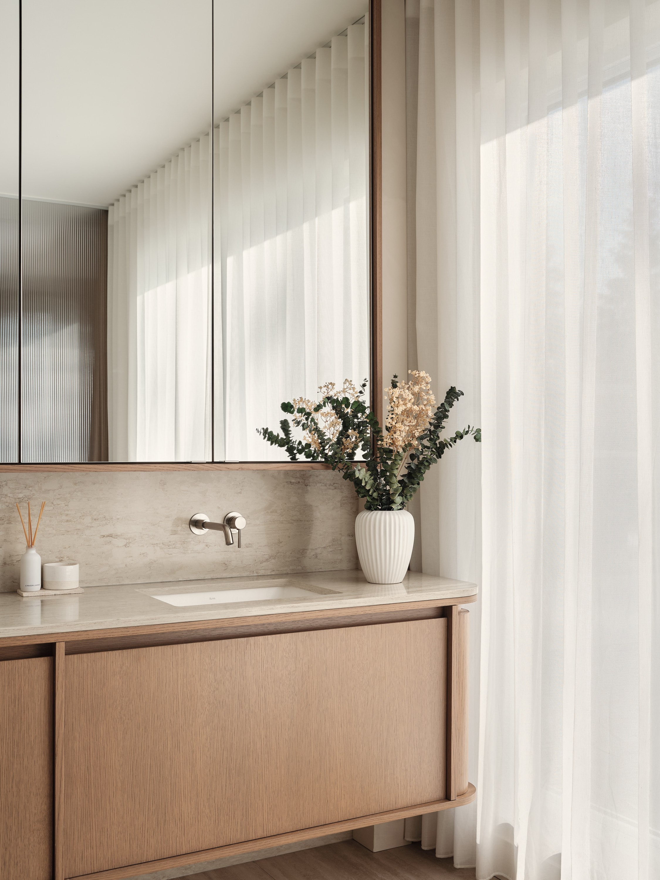 Bathroom vanity with mirror, ceramic sink, and sheer curtains