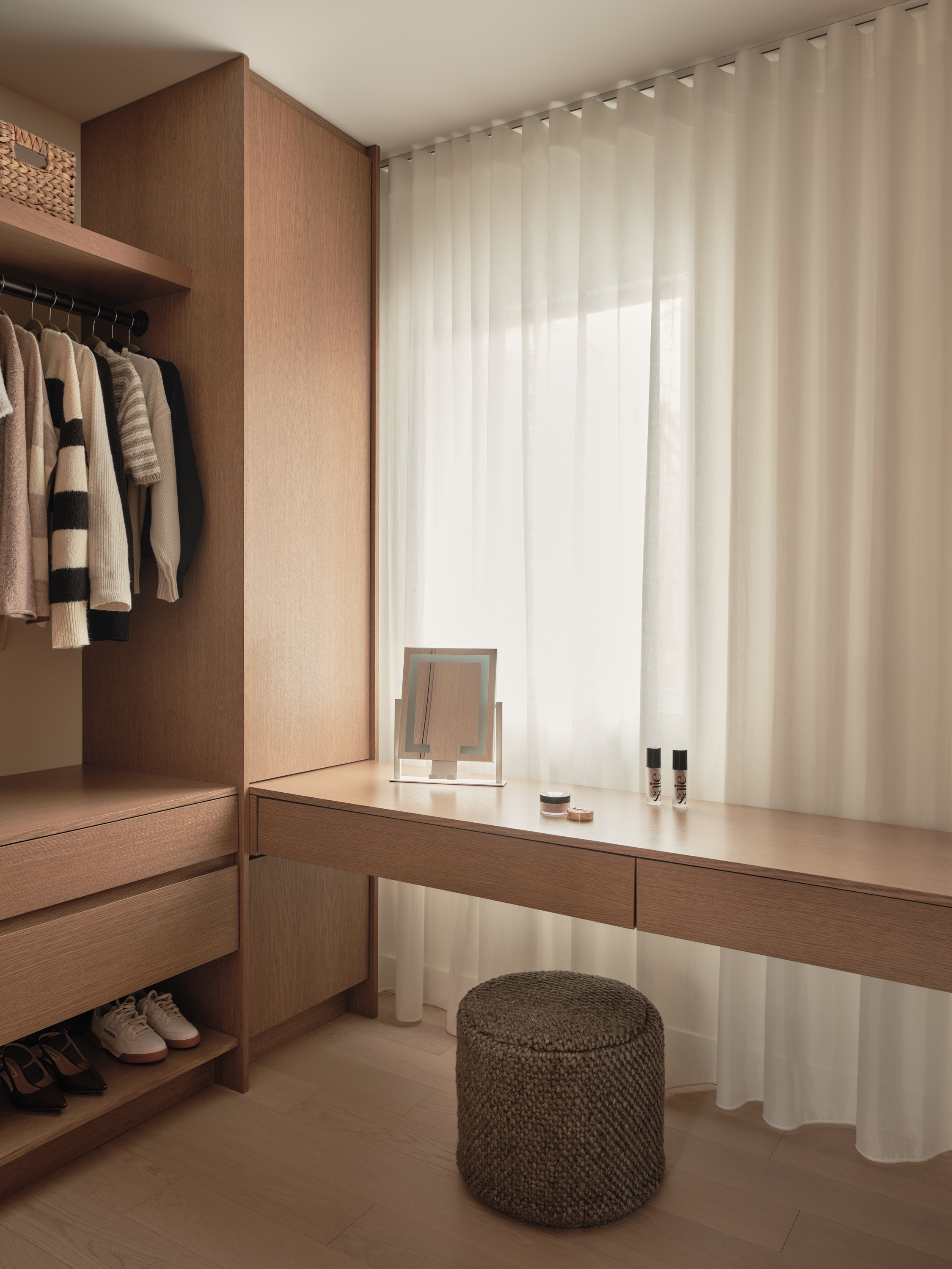 Master bedroom with a natural stone wall, pendant lights, and a wooden nightstand