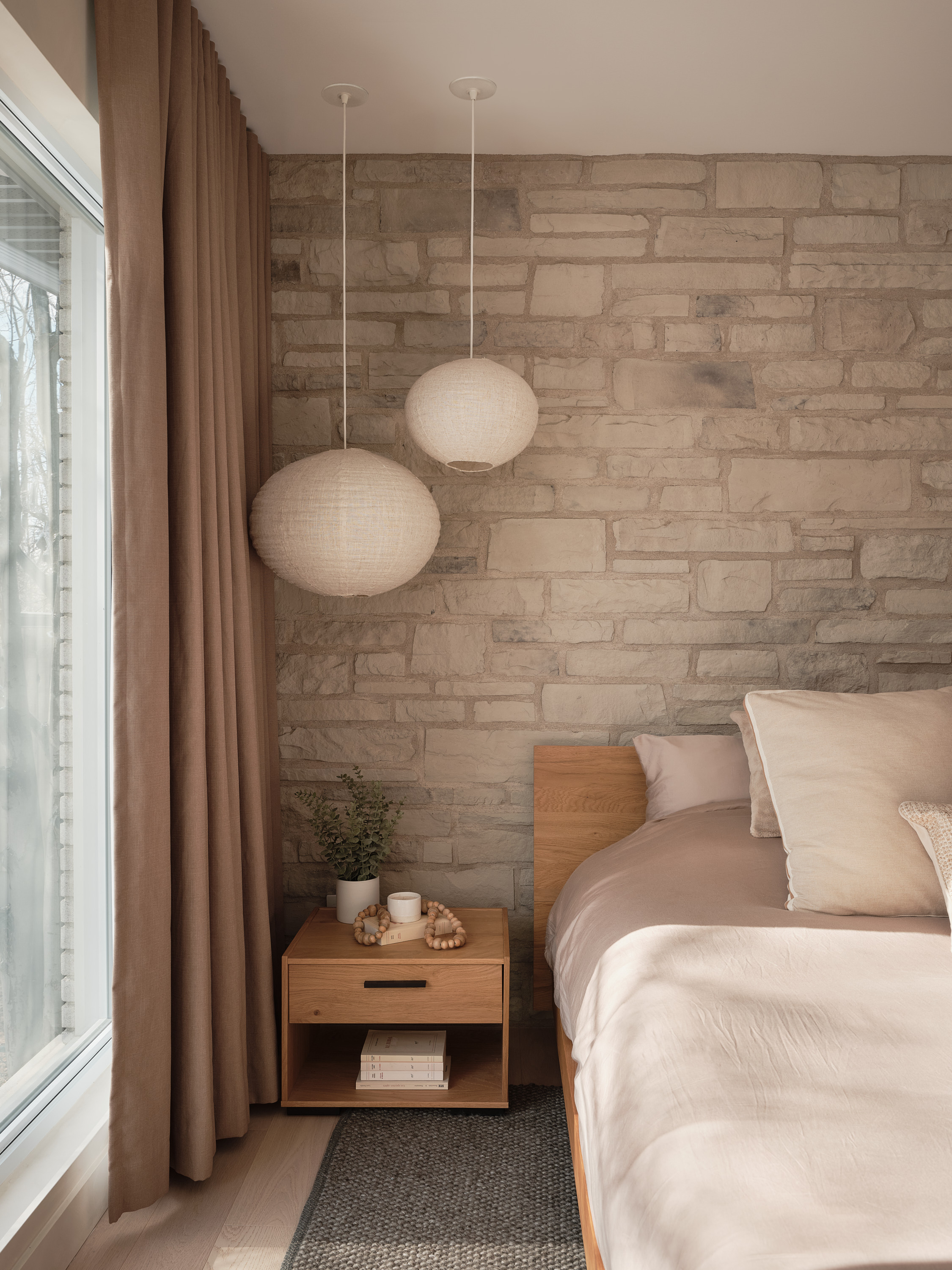 Master bedroom with rice-paper hanging decorations near the window with a sheer curtain
