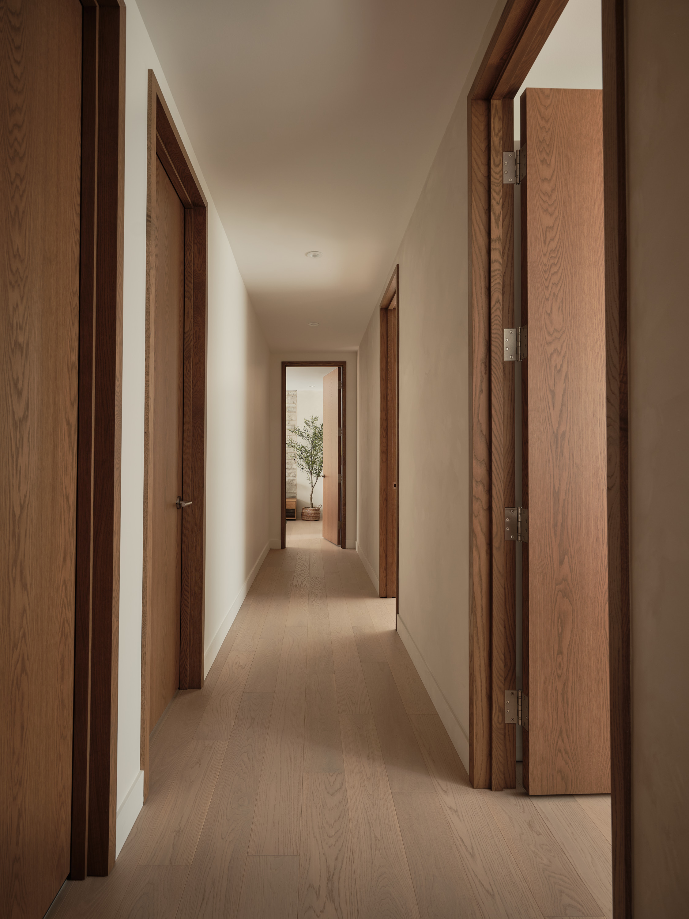 Hallway leading to the bedrooms, with wooden doors and oak flooring