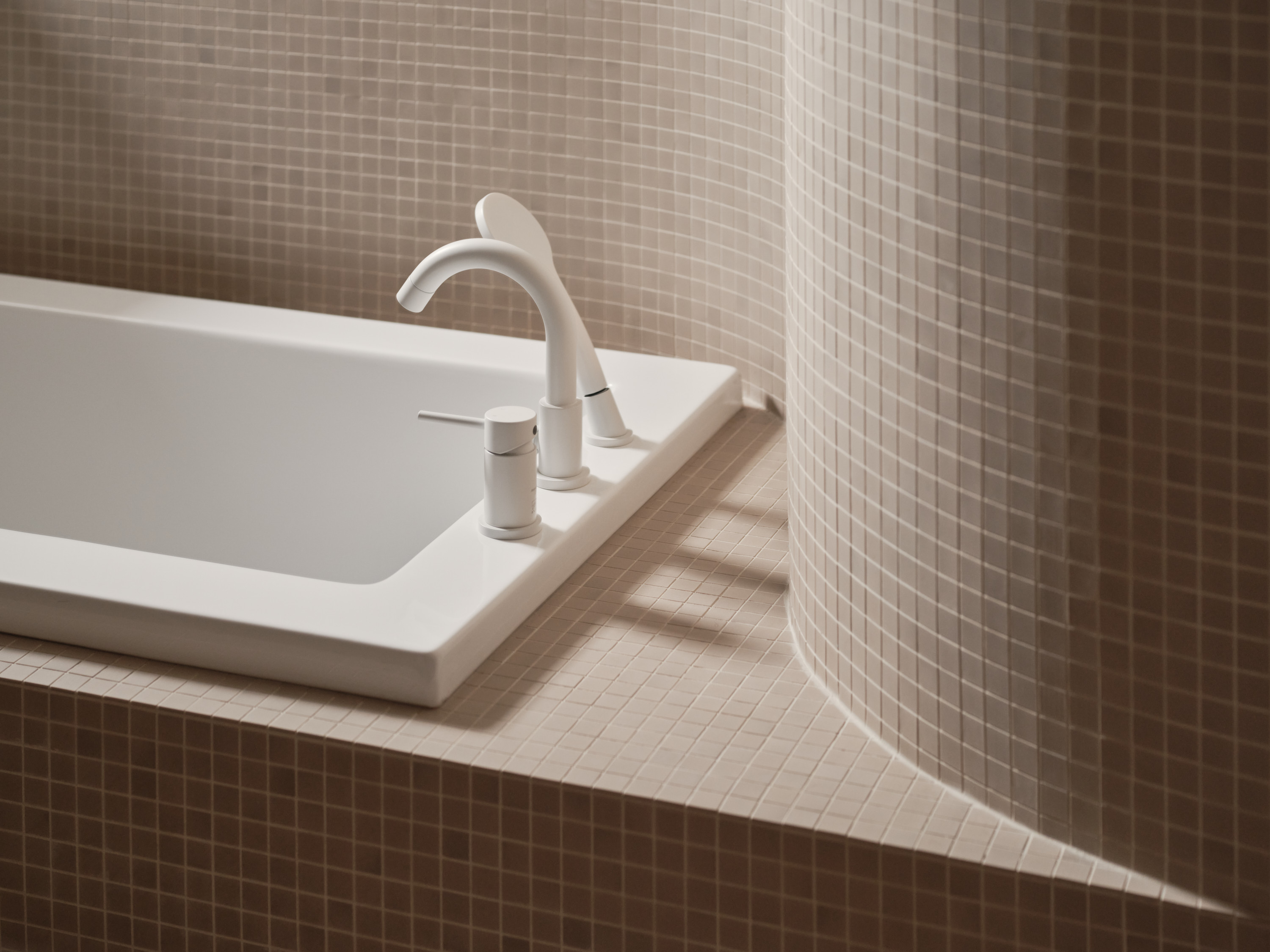 Close-up of the mosaic-tiled built-in bathtub faucet set