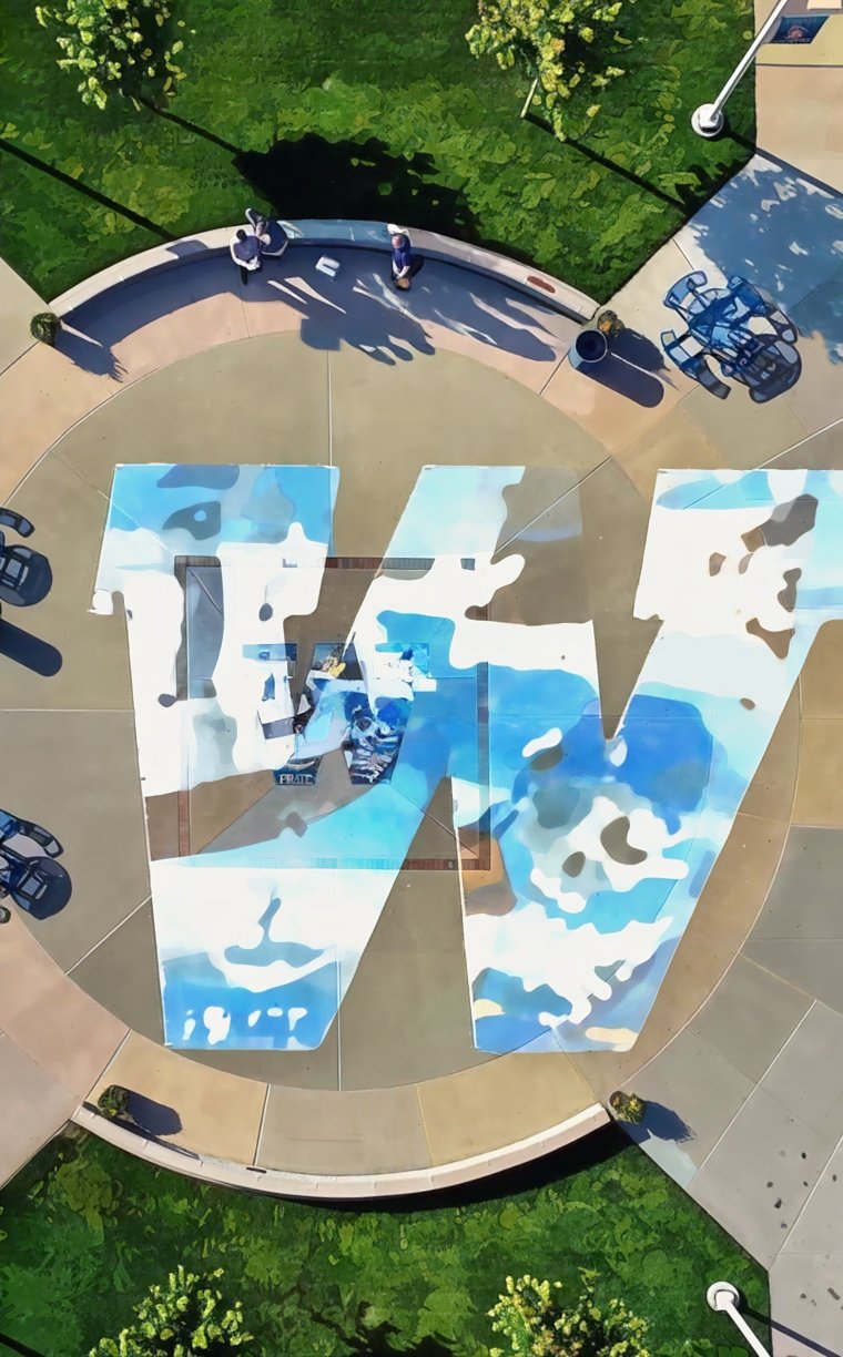 The aerial view looking down on a small campus plaza. The letter W is emblazoned across the image.