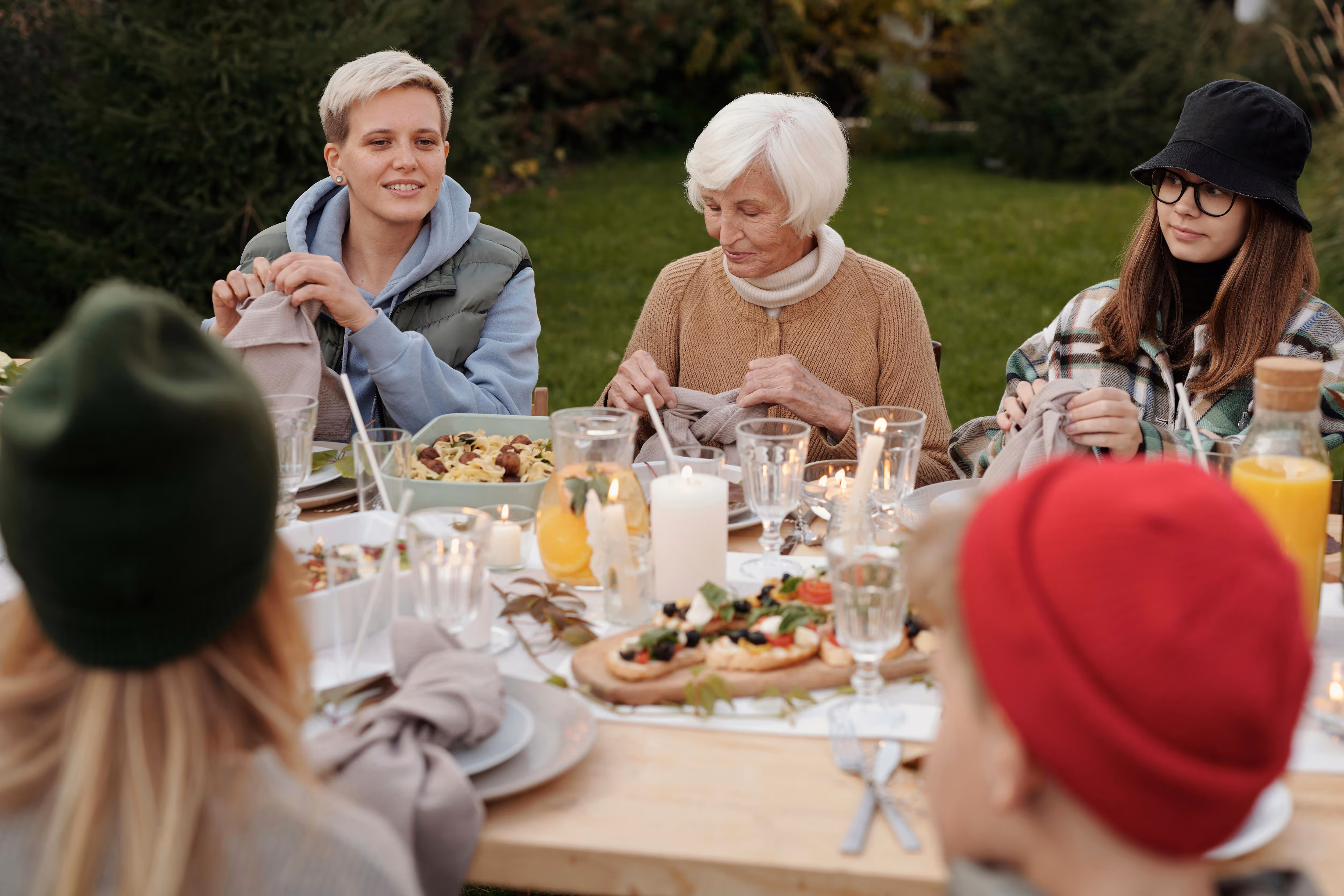 NDIS participants and support workers enjoy a communal meal outdoors, promoting community engagement and social inclusion.